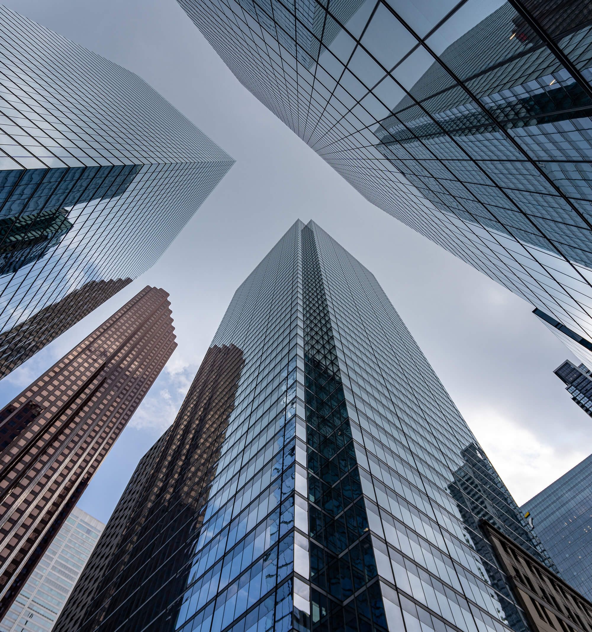 Low-angle view of glass skyscrapers reaching toward the sky, symbolizing Beaueli's brand vision for growth and innovation.